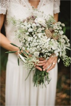 a woman holding a bouquet of flowers in her hands