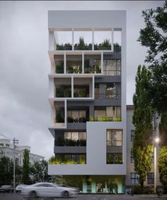 an apartment building with plants on the balconies and cars parked in front of it