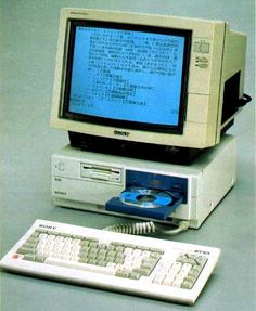 an old computer with a blue screen and keyboard sitting on the ground next to it