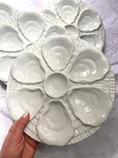 a hand is pointing at a platter that has eight plates on it and four in the middle