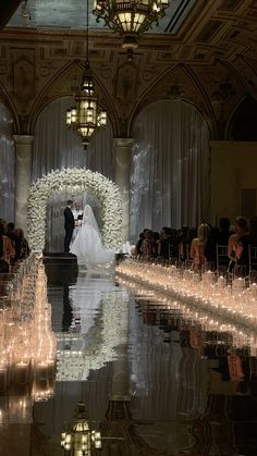 the bride and groom are standing in front of their wedding ceremony arch with lit candles