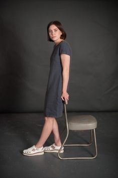 a woman standing in front of a chair