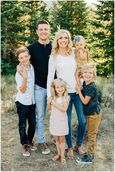 a family posing for a photo in the woods