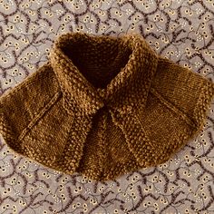 a brown knitted sweater sitting on top of a table