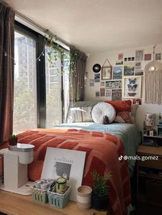 a bed room with a neatly made bed next to a window and pictures on the wall