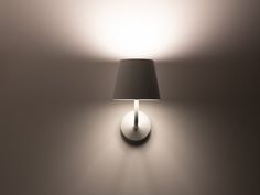 a lamp that is on the wall with a light on it's side,