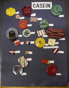 an assortment of different types of buttons and magnets on a black board with the words cassein written in white