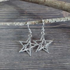 Stunning silver coloured star earrings with silver plated earring hooks.  Perfect for a gift or for a Christmas occasion! If gift box is chosen, the earrings will come in a smart black box, tied with gold ribbon, ready for gifting.  Caring for your earrings to reduce tarnishing, discolouration and damage: - Remove when bathing, showering and swimming - Avoid contact with perfume, body lotion and chemicals - Keep away from extreme humidity and sunlight - Remove prior to sleeping or physical activ Silver Star Earrings, Star Gift, Colour Star, Gold Ribbons, Silver Stars, Star Earrings, Silver Color, Lotion, Silver Plate