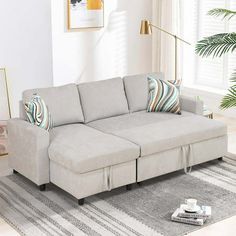 a living room with a sectional couch and pillows on the floor next to a coffee table