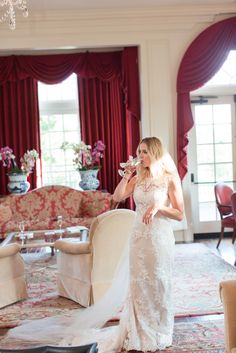 a woman in a wedding dress standing next to a couch