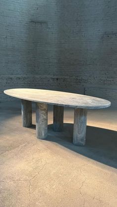 a white table sitting in the middle of a room next to a brick wall and floor