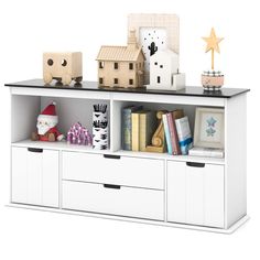 a white bookcase with drawers and toys on top