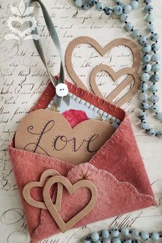 an envelope with two hearts and the word love in it is sitting on a table