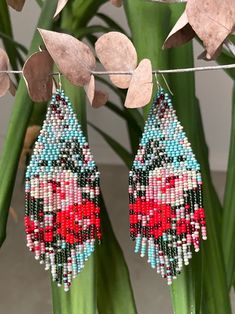 beaded earrings hanging from a plant with leaves