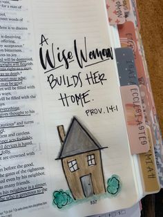 an open bible with a drawing of a house on the page and words above it