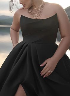 a woman in a black dress posing for the camera