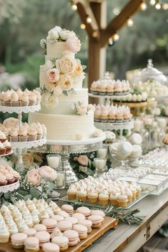 a table topped with lots of cakes and cupcakes