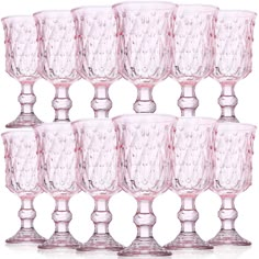 six pink glass goblets are lined up in a row on a white background