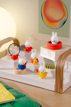 a group of toy animals sitting on top of a white shelf next to a bed