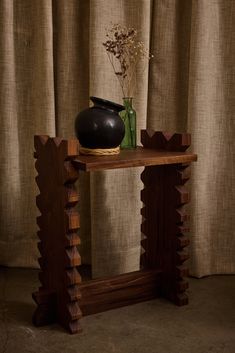 a black vase sitting on top of a wooden table