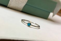 This sweet little ring is made entirely of sterling silver and features a dainty little 3mm natural blue turquoise. The band measures exactly 1mm wide, it can be worn with other rings or alone for a versatile look! The natural sleeping beauty turquoise is a 3mm round cabochon mined in Arizona, USA. It is a pure blue color with no veining or webbing, just a smooth blue color. Choose your size at check out. If you do not see your size, message me and I can help you! Comes beautifully packaged and Blue Minimalist Sterling Silver Stackable Rings, Minimalist Blue Sterling Silver Stackable Rings, Blue Minimalist Stackable Sterling Silver Rings, Stackable Sterling Silver Turquoise Ring, Minimalist Stackable Turquoise Ring For Anniversary, Luxury Stackable Turquoise Ring In Sterling Silver, Minimalist Adjustable Turquoise Ring For Everyday, Turquoise Sterling Silver Midi Rings As Gift, Minimalist Silver Turquoise Ring