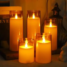 lit candles sit on a table next to an open book