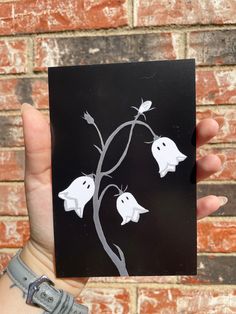 a person holding up a card with two ghost on it