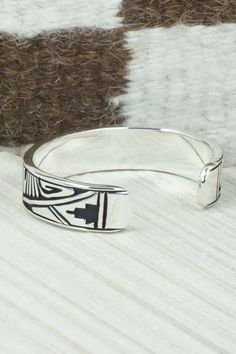 This sterling silver and bracelet was made by Navajo silversmith Kerry Begay. The inside is signed KB and stamped sterling.Size: 5" (will fit up to a 6" wrist)Gap: 1"Width: 1/2"Free shipping on all orders! We ship with USPS and always include tracking. All orders ship within a day of payment.Returns are accepted up to 30 days after you receive your order. Just send us a message. Our shop offers cash back or store credit. The item must be returned in new condition. Southwestern Sterling Silver Polished Bangle Bracelet, Southwestern Sterling Silver Bangle With Polished Finish, Southwestern Stamped 925 Cuff Bangle Bracelet, Southwestern Sterling Silver Round Cuff Bracelet, Southwestern Polished Sterling Silver Bangle, Etched Sterling Silver Bangle, Sterling Silver Etched Bangle Bracelet, Sterling Silver Southwestern Round Cuff Bracelet, Etched Sterling Silver Bangle Bracelet