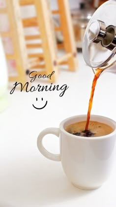 coffee being poured into a white cup with the words good morning written on it and a smiley face