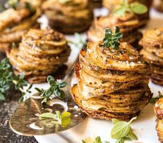 there are many stacks of pancakes on the plate with green garnishes around them