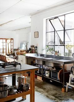 an industrial kitchen with stainless steel sink and windows