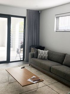 a living room with a couch, coffee table and sliding glass doors leading to the patio