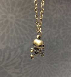 Simple, brass plated skull necklace. Choose your chain length or black cotton cord and I will make one just for you. Product details 3D human mini skull charm is bronze plated Choose your chain length with matching clasp or black cotton cord. Thank you for supporting small business VISIT MY SHOPS HERE * http://www.etsy.com/shop/HappyCatHouse * http://www.Etsy.com/shop/AnEnchantingCreature CONNECT * http://www.facebook.com/EnchantingCreature * https://instagram.com/EnchantingCreature * https://ww Metal Skull Necklace With Skull Print, Metal Skull Print Necklace For Gift, Skull Print Metal Necklace For Gift, Skull Necklace, Creating Jewelry, Skull And Crossbones, Creepy Cute, Buy Handmade, Cotton Cord