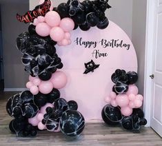 balloon arch with black and pink balloons on it