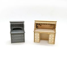 two miniature desks are shown on a white surface, one with a drawer and the other without