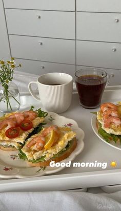 there are two plates with sandwiches on them and a cup of coffee next to it