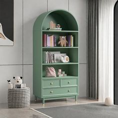 a green book shelf with books and toys on it in the corner of a room