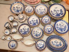 an assortment of blue and white plates on a table