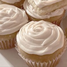 cupcakes with white frosting sitting on a plate