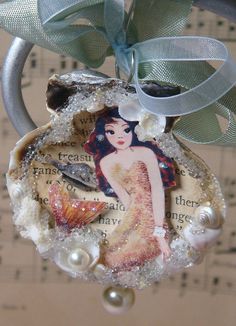 an ornament is hanging from a string with pearls and sea shells on it