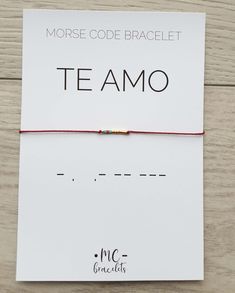 the morse code bracelet teamo is shown on top of a white card with red string