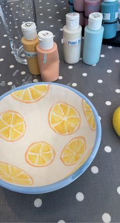 a bowl with lemons painted on it sitting on a table next to other items