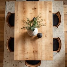 an overhead view of a wooden table and chairs with a plant in the center on top