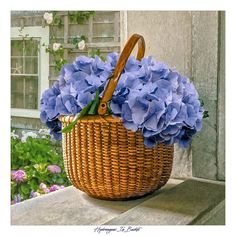 a wicker basket filled with blue flowers sitting on top of a window sill