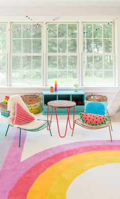 a living room filled with lots of furniture and colorful rugs on top of a white floor