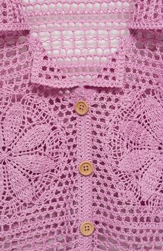 a pink crocheted shirt with buttons on the chest