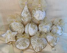 a bunch of ornaments that are sitting on a table cloth with white and gold trimmings