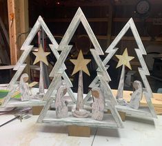 two wooden christmas trees with nativity figures in the shape of stars on top of them