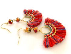 "\"Festival\" woven red and gold fan tassel earrings with Chinese Thunder Polished iridescent crystals on gold plated French hooks. Fun lightweight tassels are woven in red, gold and light and dark blue with intricate woven boarder of genuine Miyuki seed beads. Tassels are 50 x 30mm. Chinese Thunder Polished 8 x 6mm faceted rondelles in metallic gold and fuchsia are wire wrapped above for extra bling! Tassels hang from gold plated French hooks. Total length is 2 1/2\". These are very lightweight Red Tassel Earrings With Latkans As Gift, Red Tassel Earrings With Latkans For Gifts, Red Latkans Tassel Earrings For Gifts, Festive Bohemian Beaded Tassel Earrings, Red Dangle Tassel Earrings With Latkans, Red Tassel Earrings For Festive Occasions, Red Dangle Tassel Earrings For Festive Occasions, Adjustable Red Jewelry With Tassels, Adjustable Red Tasseled Jewelry