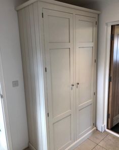 an empty room with white cupboards and tile flooring